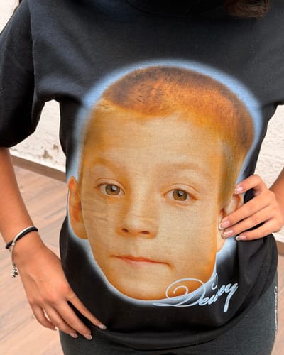 Una clienta lleva puesta la camiseta Dewey negra, que muestra el gran estampado de la cara del personaje en el pecho.