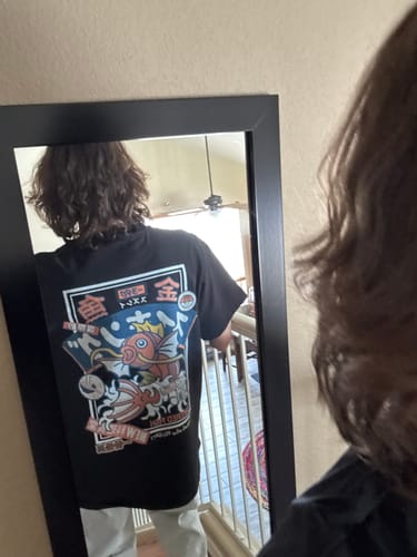 Customer's mirror selfie showing the back graphic of the black Koi King T-Shirt.