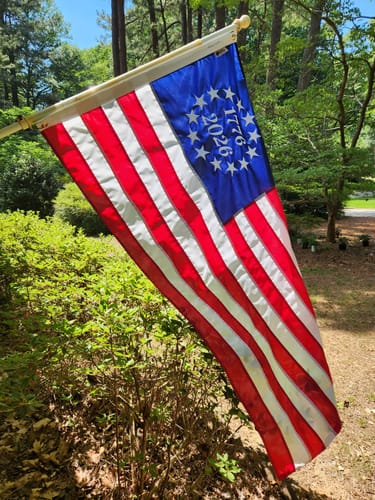 Customer's 1776 to 2026 Betsy Ross flag flying on a pole in their yard.