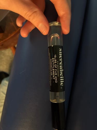 Customer holding a small spray bottle of 15 lbs of Fur and Entitlement perfume.