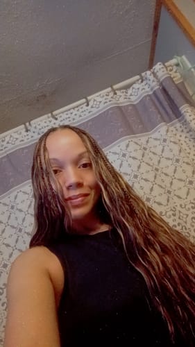 Customer's selfie showing her long #4 Medium Brown Body Wave Crochet Hair styled with thin braids.