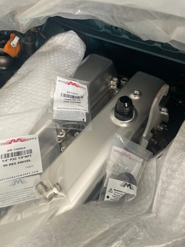 Customer's -12AN to -12ORB male aluminum fitting in its packaging, shown alongside other new engine parts.
