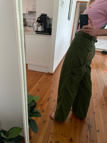 Customer's mirror selfie showing the side view and wide-leg fit of the green Construction Pants.