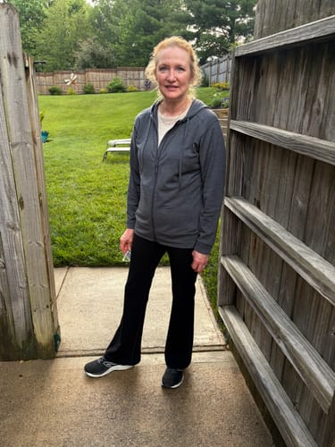 Customer standing outdoors wearing the black Morgan Flare Pants, showing the relaxed flare style.