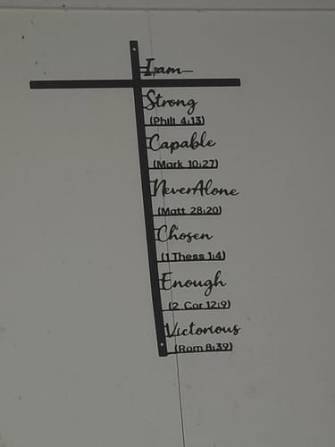 Customer's black Biblical Verse Cross Metal Wall Decor mounted on a light-colored wall.