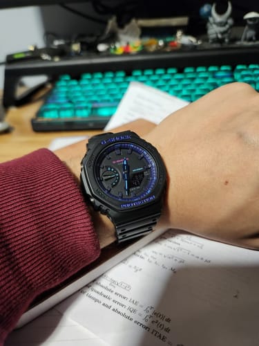 Cliente mostrando su reloj Casio G-Shock 'Casioak' negro con detalles azules en la muñeca.