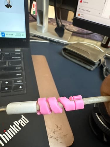 Customer's pink Cable Protector wrapped around a white cable connected to a laptop.