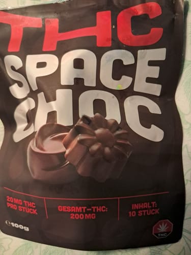 Rezensent zeigt die dunkle Verpackung der THC Schokolade SpaceChoc.