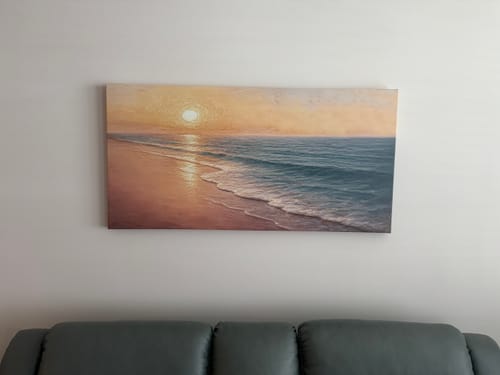 Customer's Beach Shoreline Coastal Wall Art II showing a serene sunset, hung on a wall above a dark sofa.