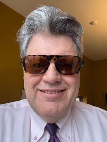Customer smiling in a close-up photo, wearing the Lason Large sunglasses with bold tortoiseshell frames.