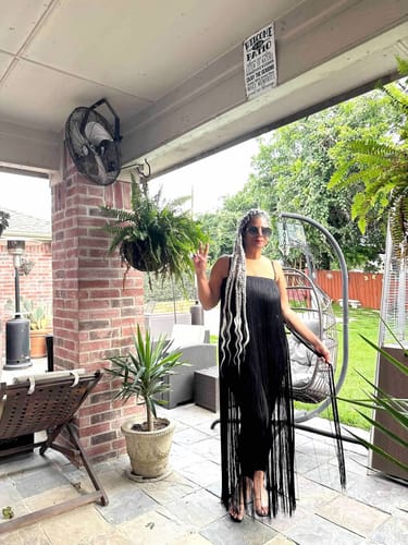 Customer posing outdoors in the black Butter Fringe Stirrup Jumpsuit.