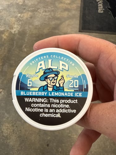 Customer's hand holding a tin of ALP Drifters Blueberry Lemonade Ice nicotine pouches.