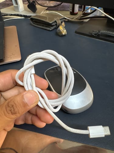 A customer holds up the coiled, white braided Casence Armor charging cable.