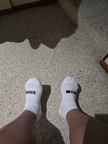 Reviewer wearing the white GAS/CLUTCH Ankle Socks on a carpeted floor.