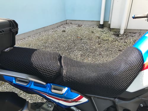 Customer's black mesh Wind Rider Seat Cover installed on a blue, red, and white motorcycle seat.