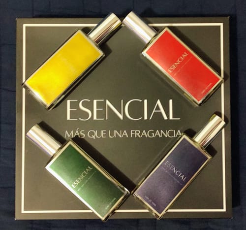 Reseñador muestra el Set Personalizado de 4 perfumes con botellas de colores sobre su estuche negro.