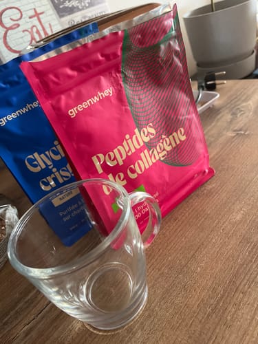 Avis d'un client : le sachet rose de Peptides de collagène posé sur une table à côté d'un mug en verre.