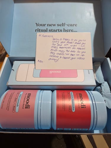Customer's Pre + Probiotic Bundle in a box, showing Pink Lemonade and Strawberry Watermelon tubs with a personal note.