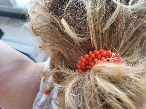 Recensent met de oranje Stiekie Dutchy haarelastiek in het blonde haar gebonden.