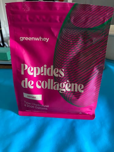 Client montrant le sachet rose de Peptides de collagène saveur Nature sur une surface bleue.
