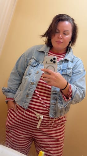 Reviewer in a mirror selfie wearing the Blush + Boysenberry Stripe PJ Set under a denim jacket.