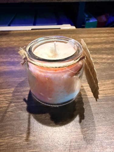 Customer's handmade pink and white candle in a glass jar, from the craft subscription box.