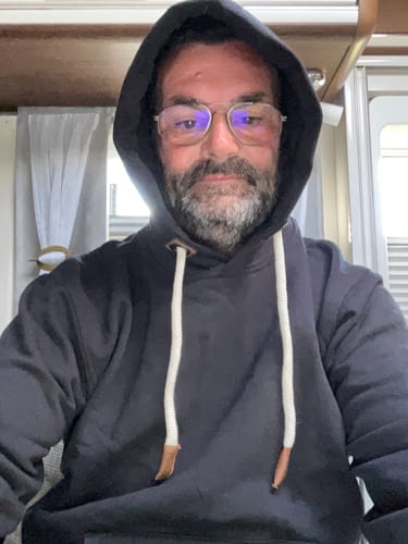 Kunde im dunklen Mooinzen Bio Jogger Zipper mit aufgesetzter Kapuze und dicken, weißen Kordeln.