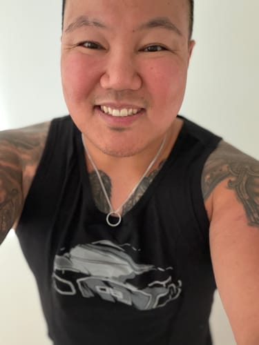 Close-up of a reviewer smiling while wearing the black 80Eighty® Limited Edition DCG89 Tank.