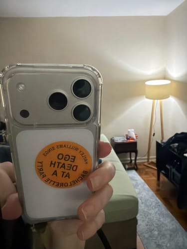 Avaliador segura um celular com a case transparente, mostrando o ajuste do produto no aparelho.