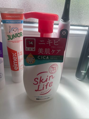 Reviewer's Skin Life Foaming Face Wash bottle with a red pump, shown on a bathroom counter with other toiletries.