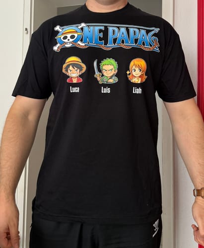 Kunde zeigt sein personalisiertes schwarzes 'One Papa' T-Shirt, das mit drei Anime-Figuren und den Namen Luca, Luis und Liah bedruckt ist.