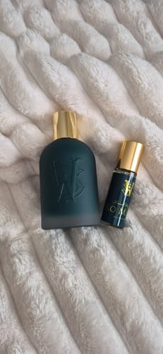 Customer's full-size Ko Meme perfume bottle and smaller travel spray on a fluffy white blanket.