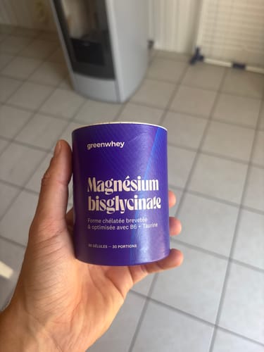 Un client tient le pot violet de Magnésium Bisglycinate dans sa main.