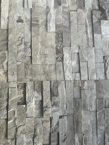 Anmelders nærbilde av Calastra kontaktplast, som viser det realistiske mønsteret av stablet stein.