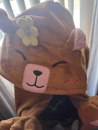 Close-up of a customer's Capybara Hooded Towel, showing the hood's embroidered animal face, ears, and a yellow flower.