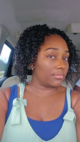 Reviewer with a short, curly style using the Water Wave Crochet Hair.