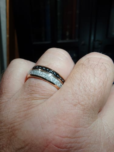 Reviewer's hand showing a close-up of the Ferox ring with its rose gold edges and textured meteorite inlay.