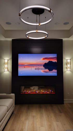 Customer's black 2-ring Matrix Rings fixture illuminated above a modern entertainment center in a living room.