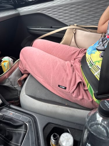 Close-up of a customer wearing the blush 80Eighty® Women's Joggers while seated in a car.