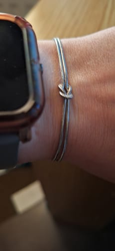 Customer's close-up view of the silver Forever Knot Bracelet on their wrist.