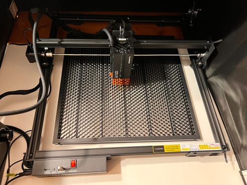 Customer's AtomStack A20 Pro V2 laser engraver, fully assembled with a black honeycomb bed inside an enclosure.