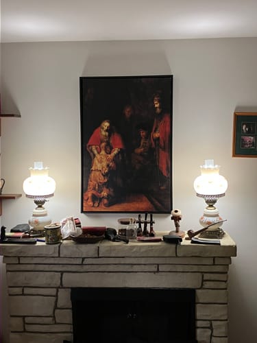 Customer's canvas of 'The Return Of The Prodigal Son' hanging above a stone fireplace between two lamps.