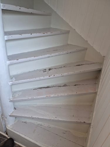 Anmelder viser den slitte, hvitmalte trappen før den ble fornyet med Oak Coffee kontaktplast.