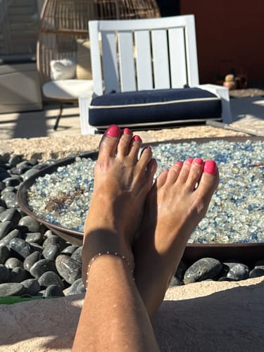 Customer's soothed feet and legs propped up outdoors after using Mama Bear Nerve Relief Lotion.