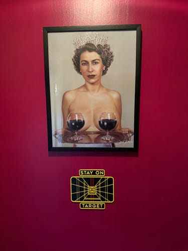 Customer's Black Oak Gallery Frame displaying a provocative art print, hung on a magenta wall.