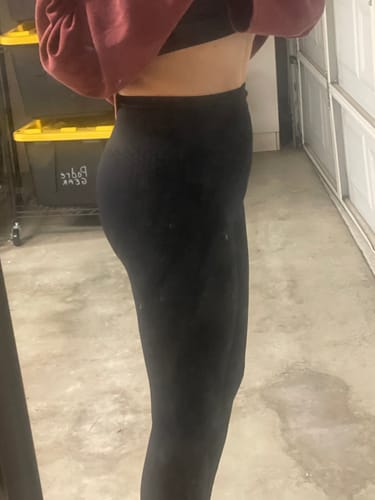 A side profile of a reviewer wearing the black, form-fitting 3D Anti-Cellulite Leggings.