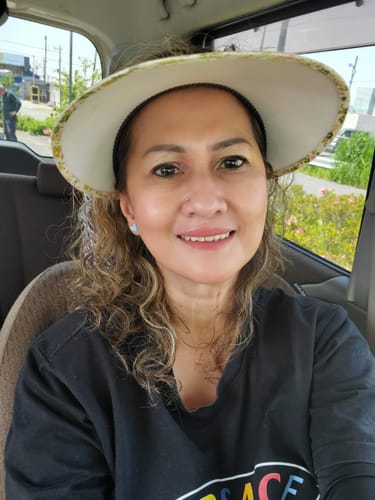 Customer smiling in a car, showing clear skin after using the Seranova Micro Infusion System.