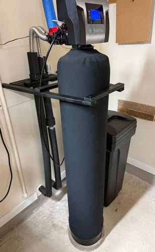 Customer's black SoftPro Elite water softener system installed and operating in a utility space.