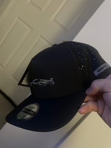 Customer holding the new, black 80Eighty DCG89 Hat with tags still attached.