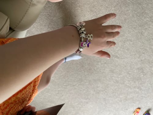 Customer showing the silver number 8 drop charm on a charm bracelet worn on a wrist.